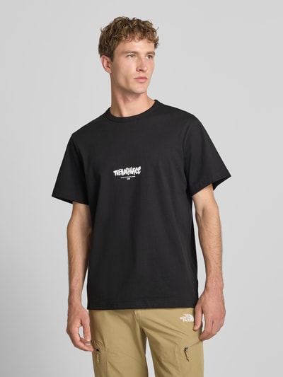 Männermodel trägt Relaxed Fit T-Shirt aus reiner Baumwolle mit Logo-Print von The North Face, Schwarz, Rundhalsausschnitt, Ganzkörperansicht von vorne.