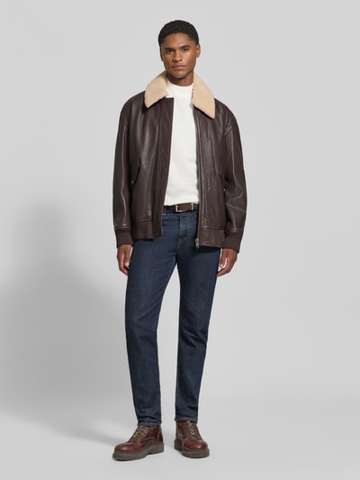 Männermodel trägt Regular Fit Lederjacke aus reinem Büffelleder Modell 'Jopeak' von BOSS Orange in brauner Lederoptik, Ganzkörperansicht von vorne.