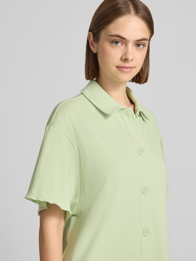 Frauenmodel trägt Relaxed Fit Bluse mit 1/2-Arm Modell 'Fleur' von OH APRIL in hellem Grün, strukturierte Oberfläche, Nahaufnahme Oberkörper, Damen Bluse aus Baumwoll-Mix mit Modal-Anteil, Hemdblusenkragen, Knopfleiste, Rückenlänge 68 cm, Ärmellänge 20 cm.