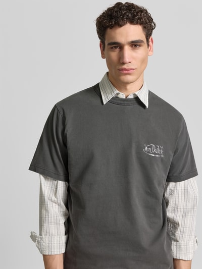 Männermodel trägt Relaxed Fit T-Shirt aus reiner Baumwolle von ANNARR, dunkelgrau, Label-Print, Rundhalsausschnitt, Kurzärmelig, Nahaufnahme Oberkörper.