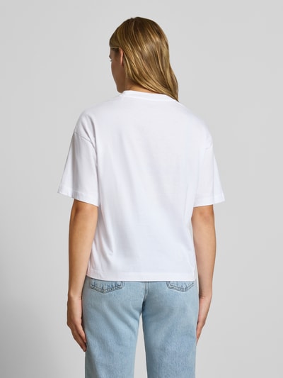 Frauenmodel trägt Regular Fit T-Shirt aus reiner Baumwolle Modell 'CHESTER' von Carhartt Work In Progress in Weiß, glatte Textur, Ganzkörperansicht Rückansicht, Rückenlänge bei Größe S 56 cm.