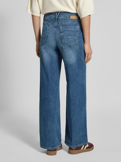 Frauenmodel trägt Wide Leg Medium Waist Jeans Modell 'CARLOTTA' von GANG im Used-Look, Baumwoll-Mix mit Stretch-Anteil, Eingrifftaschen, Ganzkörperansicht Rückansicht.