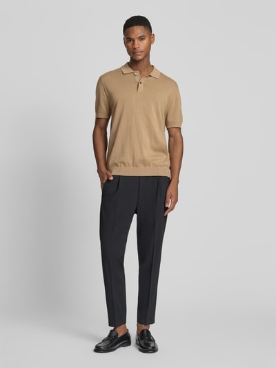 Männermodel trägt Hose mit Eingrifftaschen Modell 'CHASY' von Drykorn, schwarze Tapered Fit Hose mit elastischem Bund, Ganzkörperansicht von vorne.