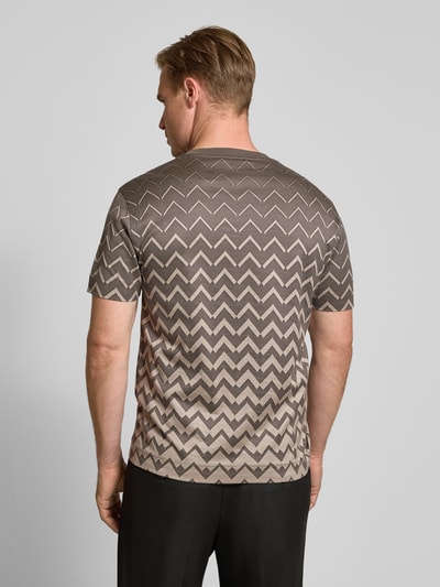 Männermodel trägt T-Shirt mit Rundhalsausschnitt von Emporio Armani, Baumwoll-Lyocell-Mix, Zickzack-Muster in Brauntönen, Ganzkörperansicht Rückansicht.