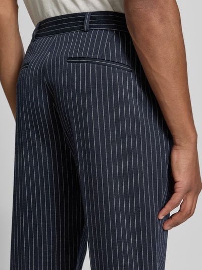 Männermodel trägt Straight Fit Hose mit Schurwoll-Anteil Modell 'Connor' von Zuitable, feine Nadelstreifen, Material-Mix, Detailaufnahme.
