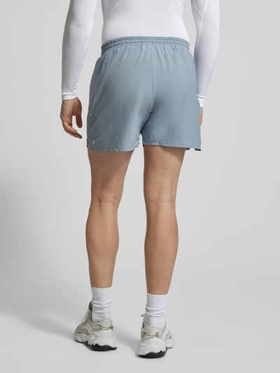 Männermodel trägt Shorts mit elastischem Bund und Logo von Salomon in Hellblau, Regular-Fit, Ganzkörperansicht Rückansicht. Kontext: Herren Shorts, elastischer Bund, Tunnelzug, Logo, Bundweite bei Größe M 41 cm, Innenbeinlänge bei Größe M 12 cm.