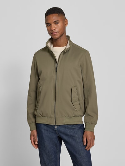 Männermodel trägt Regular Fit Blouson mit Stehkragen von Tom Tailor in Olive, unifarben, Twill-Textur, seitliche Pattentaschen, Ganzkörperansicht von vorne.
