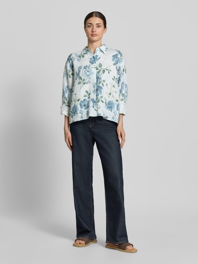 Männermodel trägt Regular Fit Hemdbluse aus Leinen von Jake*s Collection, weiß mit blauem Blumenmuster, krój regular fit, Kentkragen, Knopfleiste, oversize ramiona, długość tyłu 64 cm, długość rękawa 57 cm; Ganzkörperansicht von vorne.