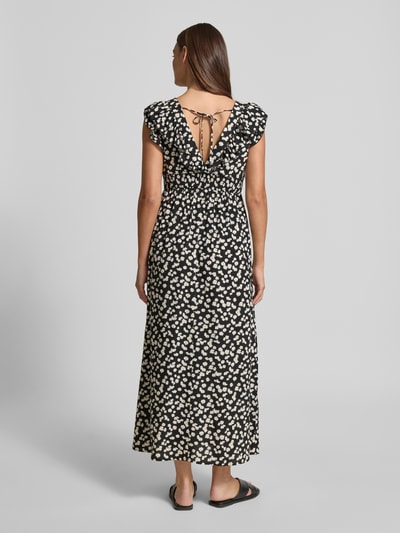 Frauenmodel trägt Leicht ausgestelltes Maxikleid aus reiner Viskose Modell 'EASY JOY' von Vero Moda, Optik:Allover-Muster, Maxi, Rüschen, Gummizug, Bindeverschluss, Volant-Saum, Material: reine Viskose, Ganzkörperansicht Rückansicht.