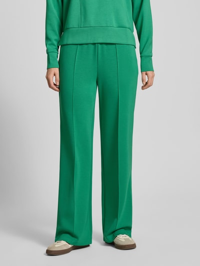 Kobiece model prezentuje Sweatpants mit elastischem Bund od Christian Berg Woman, luźny krój, z kieszeniami, z przodu, zbliżenie na nogi.