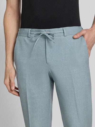 Männermodel trägt Hose mit Bügelfalten und Schnürung Modell 'SpartaFlex' von Zuitable, Slim Fit, Nahaufnahme Oberkörper, Material-Mix mit Viskose-Anteil, hellblauer Farbton, feine Struktur.