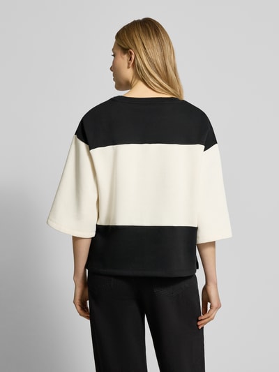 Frauenmodel trägt Sweatshirt mit geripptem Rundhalsausschnitt Modell 'ANGELIN' von Soyaconcept in Schwarz und Creme, lockerer Schnitt, 3/4-Ärmel, Baumwoll-Mix, Ganzkörperansicht Rückansicht.
