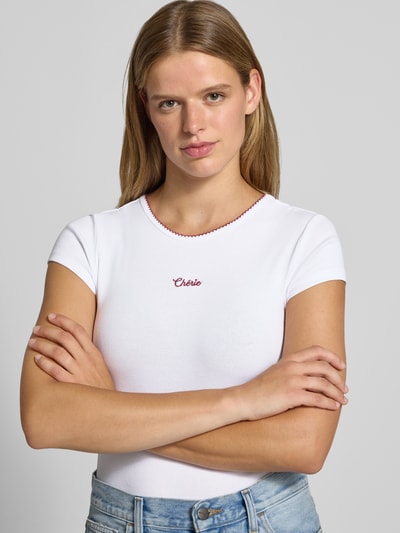 Vrouwenmodel draagt T-Shirt met Statement-Stitching van REVIEW in wit katoenmix met mix van biologisch katoen, nauwsluitend model, ronde hals, ruglengte maat S 51 cm, nahaufnahme bovenlichaam.