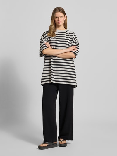 Frauenmodel trägt Weite Hose in Crêpe-Verarbeitung Modell 'TIFFANY' von Pieces, Optik: Unifarben, Passform: Wide Leg, Bundabschluss: Elastisch, seitliche Eingrifftaschen, Materialverarbeitung: Crêpe, Ganzkörperansicht von vorne.