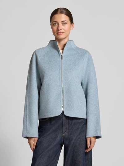 Kobiece modelka nosi Relaxed Fit Kurzmantel Modell 'Helisu' od OPUS, jasnoniebieski, matowy, strukturalny wzór, filcowany wełniany miks, stójka, długi rękaw raglanowy, zapinany na zamek, zaokrąglony dół, widok całej sylwetki z przodu.