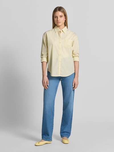 Frauenmodel trägt Wide Leg Jeans mit Eingrifftaschen von Emporio Armani aus blauem Baumwoll-Lyocell-Mix im Used-Look, Ganzkörperansicht von vorne.