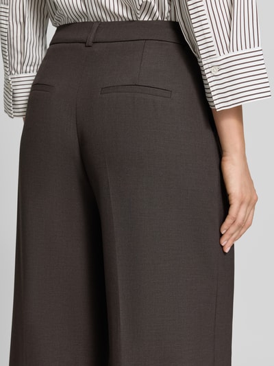 Frauenmodel trägt Wide Fit Hose aus Viskose-Mix von comma, dunkelbraune Farbe, Gesäßtaschen, Detailaufnahme Rückansicht.