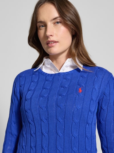Frauenmodel trägt Strickpullover mit Zopfmuster Modell 'JULIANNA' von Polo Ralph Lauren in Blau, Rundhalsausschnitt, Nahaufnahme Oberkörper.
