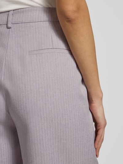 Młody kobiecy model nosi spodnie z szerokimi nogawkami, wpuszczane kieszenie, mieszanka materiałów z dodatkiem wiskozy, model 'Rosie' od LOLLYS LAUNDRY, szerokość w rozmiarze S: 37 cm, długość wewnętrzna nogawki w rozmiarze S: 79 cm, zbliżenie na tył.