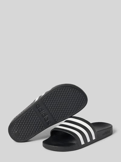 Productfoto, Badeschuhe mit Kontraststreifen Modell 'ADILETTE AQUA' van adidas Sportswear, zwart met witte streepmotief, afgeronde punt, platte hakvorm, gestructureerde zool, comfortmodel/open, all-over motief.