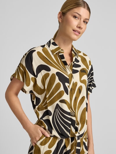 Frauenmodel trägt Regular Fit Bluse aus Viskose mit Knotendetail Modell 'FELDI' von Soyaconcept, Allover-Look in Beige und Schwarz, Nahaufnahme Oberkörper.