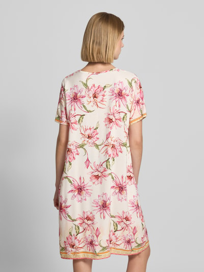 Frauenmodel trägt Knielanges Tunikakleid mit V-Ausschnitt Modell 'Ha44zell' von ZABAIONE, Allover-Blumenprint in Rosa und Grün, Rückansicht, Ganzkörperansicht Rückansicht. Reine Viskose, gerader Schnitt, knielang, Rückenlänge 93 cm, Brustweite 52 cm, Ärmellänge 21 cm.
