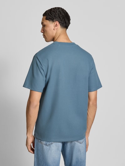 Männermodel trägt T-Shirt mit Rundhalsausschnitt Modell 'AUSTIN' von Jack & Jones in Blau, Elastischer-Material-Mix, Gerader-Schnitt, Rückenlänge 68 cm, Ganzkörperansicht Rückansicht.