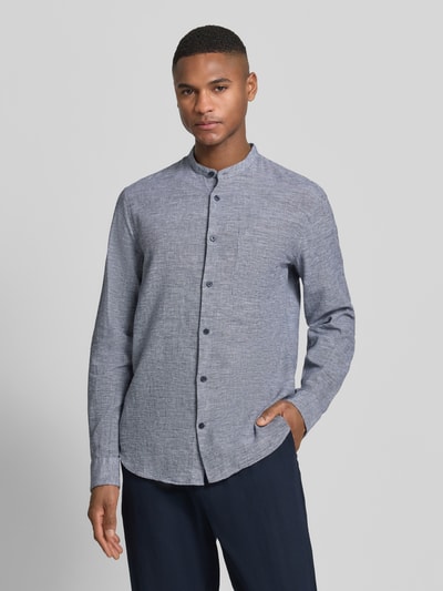 Männermodel trägt Regular Fit Leinenhemd mit Brusttasche Modell 'Atrostol' von Matinique, meliertes Blau, Stehkragen, Ganzkörperansicht von vorne. Baumwolle-Leinen-Mix, Langärmelig, Knopfleiste, Sportmanschetten, Rückenlänge 76 cm, Schulterbreite 40 cm, Ärmellänge 64 cm.