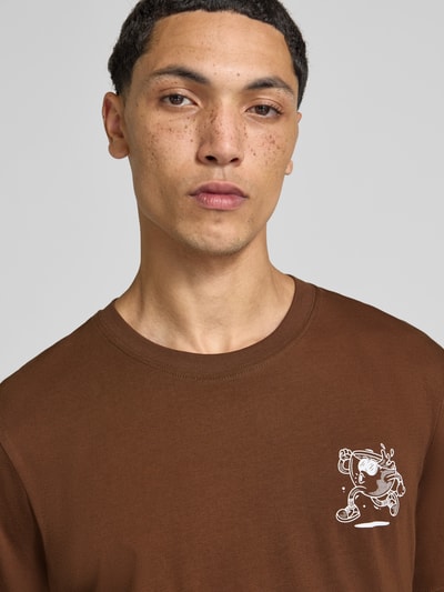 Męski model nosi Regular Fit T-Shirt aus reiner Baumwolle Modell 'BREWY' von JACK & JONES, brązowy kolor, nadruk z napisem, kontekst: Męski t-shirt z bawełny, krój regular fit, długość tyłu w rozmiarze M: 68 cm, nadruk z napisem, Nahaufnahme Oberkörper.