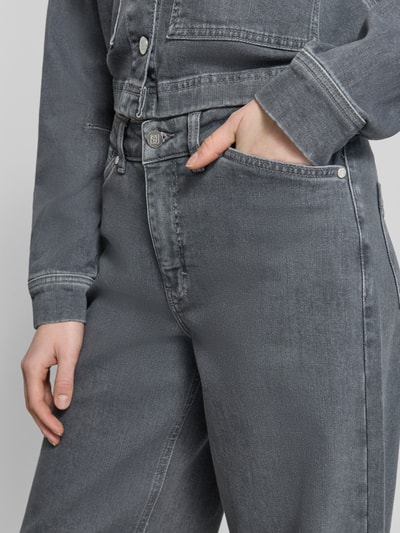 Kobiece model prezentuje Relaxed Fit Jeans aus Baumwoll-Mix Modell 'Cellma Edge' od Someday, szary denim, mieszanka bawełny i elastanu, wpuszczane kieszenie, szlufki na pasek, zapięcie na guzik i zamek błyskawiczny, szerokość w rozmiarze 36: 38 cm, długość wewnętrzna nogawki w rozmiarze 36: 79 cm, detaliczna faktura tkaniny, widok z przodu zbliżenie na biodra i kieszeń.