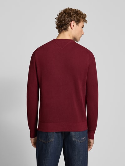 Mężczyzna model prezentuje Regular Fit Pullover aus reiner Baumwolle von Tommy Hilfiger, bordowy, tekstura gładka, całkowity widok z tyłu.