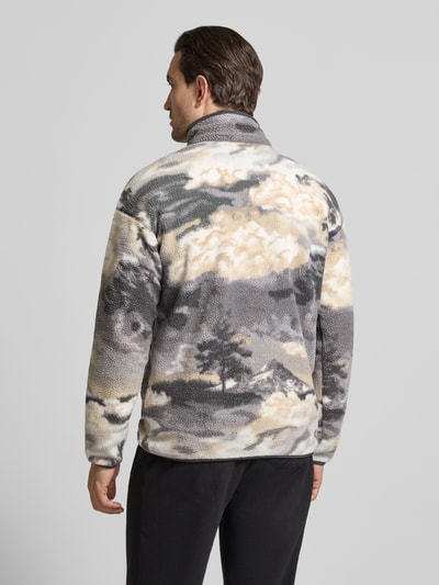 Männermodel trägt Regular Fit Pullover mit Logo-Patch von Columbia w szaro-beżowej fließ-Optik, Ganzkörperansicht Rückansicht