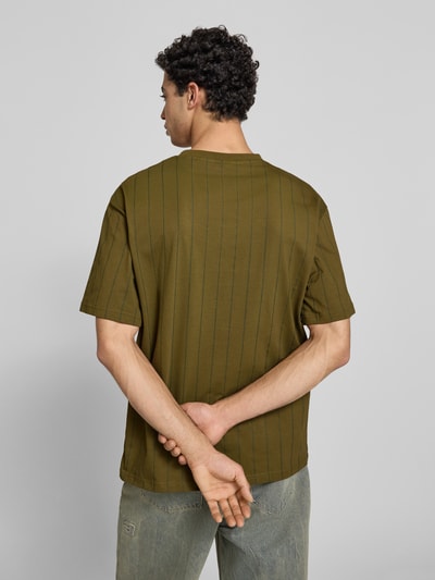 Männermodel trägt Relaxed Fit T-Shirt mit Logo-Stitching von KARL KANI, Reine Baumwolle, olivgrün, Rundhalsausschnitt, Rückenlänge 71 cm, Ganzkörperansicht Rückansicht