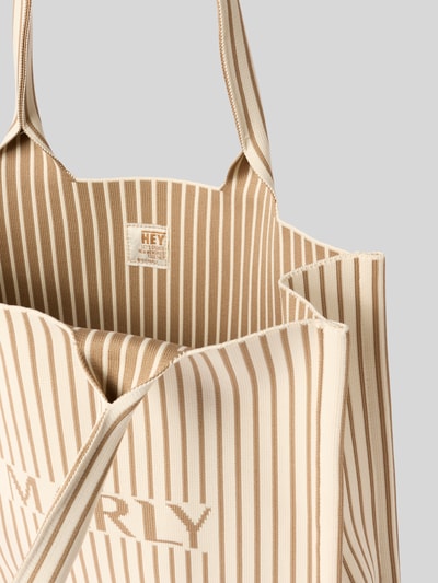 Produktfoto, Strandtasche mit Label-Detail Modell 'Summer Signatur' von Hey Marly, gestreifte Struktur in Beige und Creme, kurze Tragegriffe, offenes Hauptfach, zusätzliche Reißverschlusstasche, Maße: Breite 33 cm, Länge 43 cm, Tiefe 15 cm, Schulterriemen 64 cm.