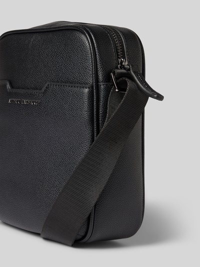 Produktfoto, Handtasche mit verstellbarem Schulterriemen von ARMANI EXCHANGE, schwarzes, strukturiertes Kunstleder, silbernes Label-Detail, Reißverschluss, rechteckige Form, Schulterriemen verstellbar, Maße 16x21x9 cm, Länge Schulterriemen 82 cm.