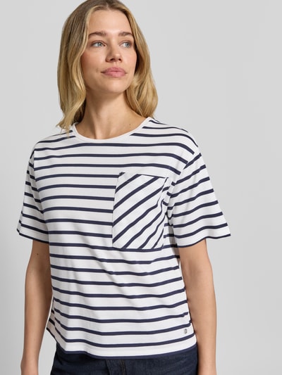 Vrouwenmodel draagt T-shirt met borstzak en ronde hals van monari, mix van katoen en modal, recht model, labeldetail, ruglengte maat 36: 54 cm. Nahaufnahme Oberkörper.