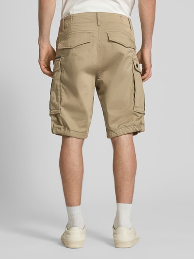 Männermodel trägt Bermudas mit Pattentaschen Modell 'ROVIC ZIP' von G-Star Raw aus Baumwoll-Mix mit Stretch-Anteil, Straight Fit, Ganzkörperansicht Rückansicht.
