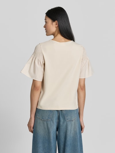 Frauenmodel trägt Regular Fit T-Shirt mit Smok-Detail von Comma aus reiner Baumwolle, ausgestellte Ärmel, kurzärmelig, cremefarben, Ganzkörperansicht Rückansicht.