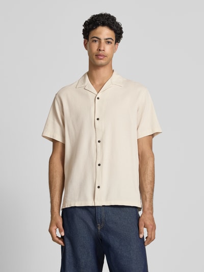 Männermodel trägt Regular Fit Freizeithemd mit Strukturmuster Modell 'Global' von Jack & Jones, naturfarben, kurzärmelig, Ganzkörperansicht von vorne. Strukturierte Baumwolle, Reverskragen, durchgehende Knopfleiste, lockerer Schnitt.