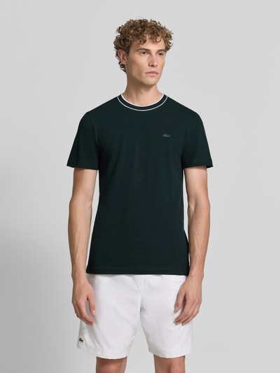 Męski model nosi Regular Fit T-Shirt aus Baumwoll-Mix von Lacoste w kolorze ciemnozielonym, gładka struktura, Ganzkörperansicht von vorne