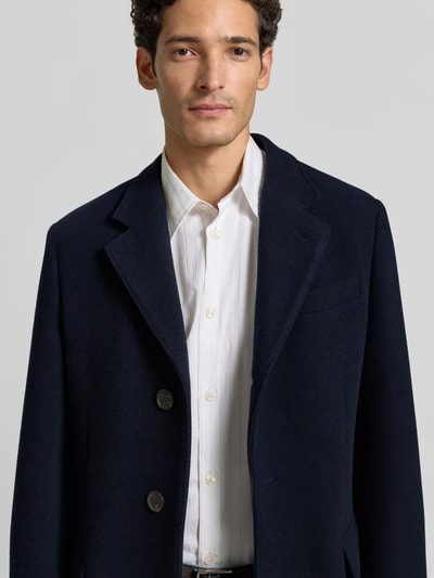 Męski model nosi Regular Fit płaszcz z mieszanki wełny od Polo Ralph Lauren, granatowy kolor, miękka faktura, zbliżenie na górę ciała.