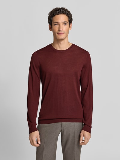 Männermodel trägt Strickpullover aus Schurwolle mit Rundhalsausschnitt von MAERZ Muenchen in Bordeaux, Regular Fit, Ganzkörperansicht von vorne