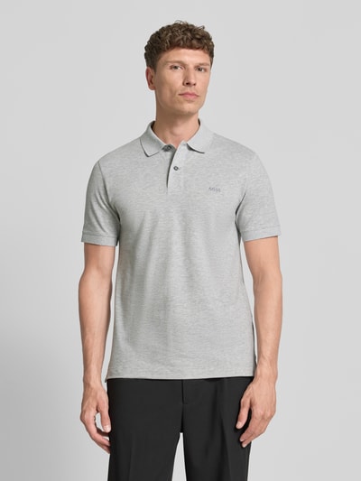 Männermodel trägt Regular Fit Poloshirt aus reiner Baumwolle Modell 'PALLAS' von BOSS in Hellgrau mit Polokragen und kurzer Knopfleiste, Ganzkörperansicht von vorne.