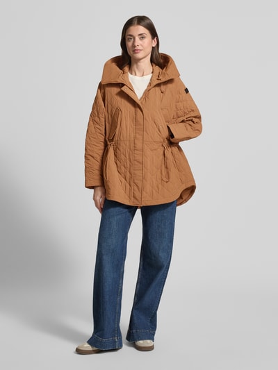 Frauenmodel trägt Relaxed Fit Jacke in Stepp-Optik Modell 'Texel' von Peuterey in Braun, mit Stehkragen, Pattentaschen und Tunnelzug in der Taille, matte Textur, Ganzkörperansicht von vorne. Rückenlänge 80 cm, Schulterbreite 50 cm, Brustweite 72 cm, Ärmellänge 59 cm.