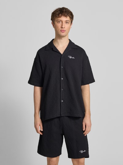 Männermodel trägt zwart heren vrijetijdsoverhemd Regular Fit model 'Jovren' van Pegador in elastische materiaalmix met katoen, halflange mouwen, reverskraag, knoopsluiting en labelstitching, ruglengte maat M 72 cm, schouderbreedte 45 cm, mouwlengte 33 cm, gestructureerde textuur, voorkant, Ganzkörperansicht von vorne.