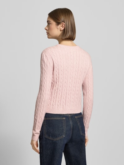 Frauenmodel trägt Shaped Fit Cardigan aus Viskose-Mix Modell 'KATIA' von Only in zartem Rosa, Zopfmuster, Strickoptik, Ganzkörperansicht Rückansicht.