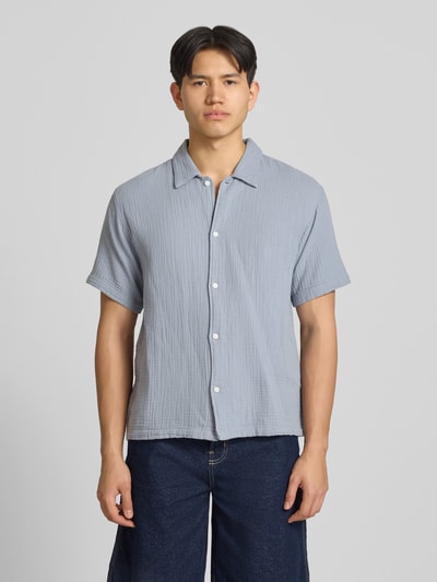 Männermodel trägt Regular Fit Freizeithemd mit Kentkragen von Jack & JonesR, reine Baumwolle, hellblau, Knopfleiste, Halbarm, Ganzkörperansicht von vorne.