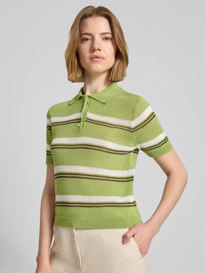 Frauenmodel trägt Slim Fit Poloshirt in Strick-Optik Modell 'Verdi' von Mango in Grün mit Streifen, Material-Mix, Nahaufnahme Oberkörper.