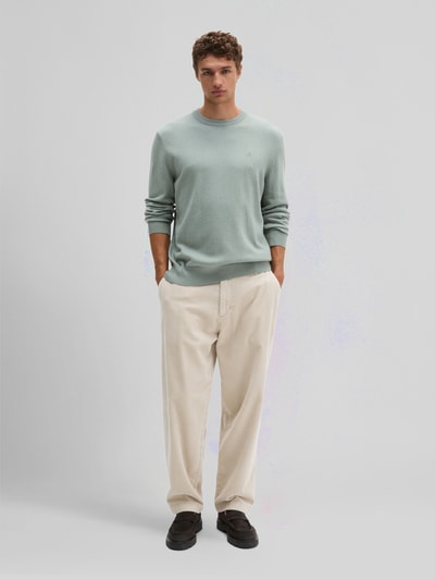 Männermodel trägt Regular Fit Pullover aus Baumwoll-Mix mit Schurwoll-Anteil von Marc O'Polo in hellem Grün, Ganzkörperansicht von vorne. Herren Pullover von Marc O'Polo