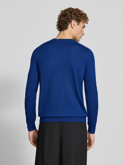 Männermodel trägt Strickpullover aus Woll-Mix mit V-Ausschnitt von Christian Berg Men in Blau, glatte Textur, Ganzkörperansicht Rückansicht. Regular Fit, gerippte Abschlüsse, Rückenlänge 71 cm, Ärmellänge 73 cm.